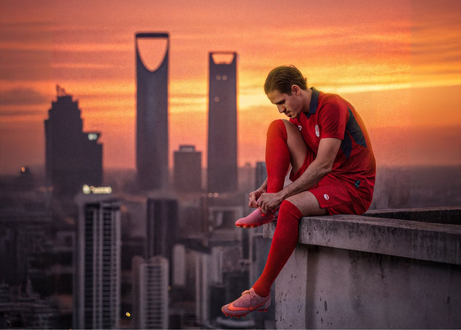 Miêu tả thực tế hay trừu tượng? Poster chính thức của DAMAC: Các cầu thủ ngồi trên mép sân thượng để buộc dây giày